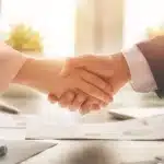 A photo of a man and a woman shaking hands.