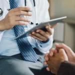 A photo of a doctor holding a tablet.